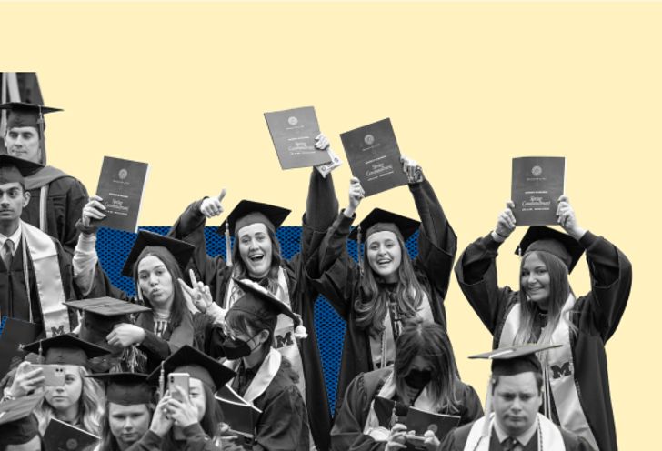 Graduates holding up their commencement program booklets